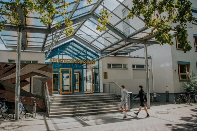 Foto: Zwei Schüler laufen die Treppe zum Eingang ins Schulgebäude hoch.
