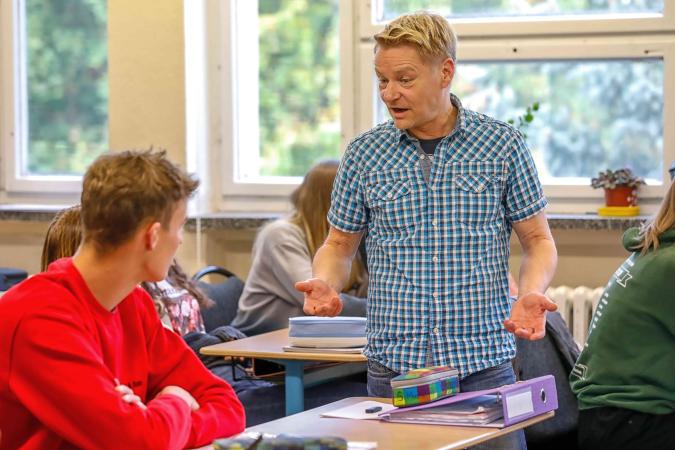 Unterrichtssituation mit Lehrkraft und Schüler im Austausch