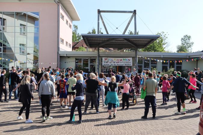 Schulgemeinschaft auf dem Schulhof mit Sportsachen