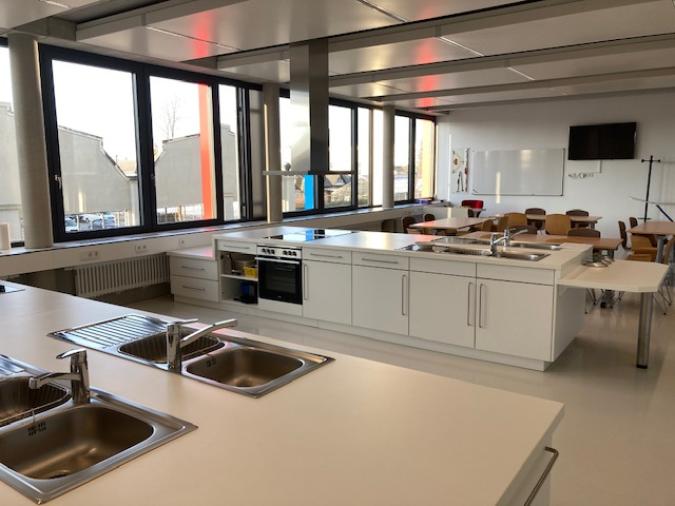 Lehrküche mit vier Küchenzeilen an denen die Kinder arbeiten können