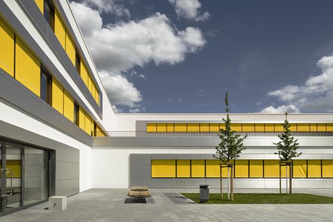 Außenansicht der Schule mit gelben Rollos