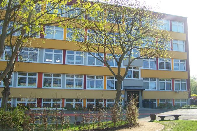 Es ist ein rot-gelbes Gebäude mit vielen Fenstern.