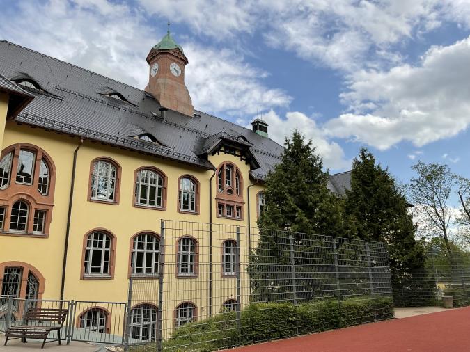 Die Lindenschule Crimmitschau vom Hof aus gesehen. Ein 4-geschossiges Gebäude mit schönem Uhrenturm.